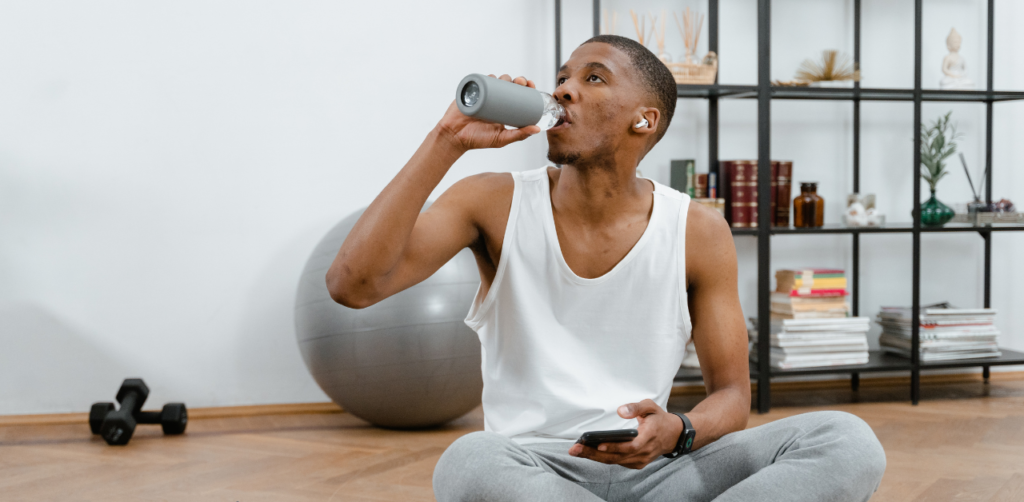 a boy drinking water with reusable water bottle in fitness center